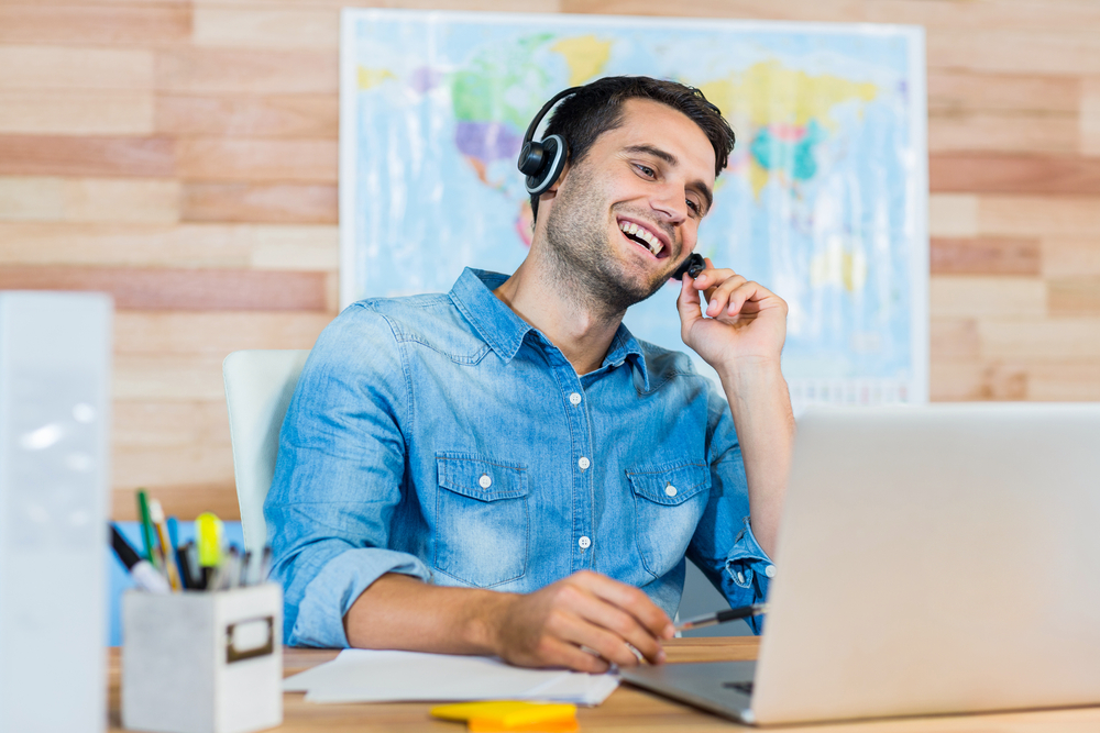 Handsome travel agent speaking with customer in the office